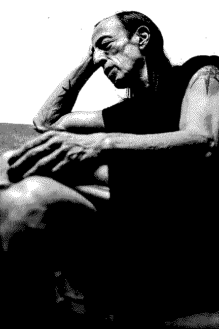Black and white halftone portrait of a seated man